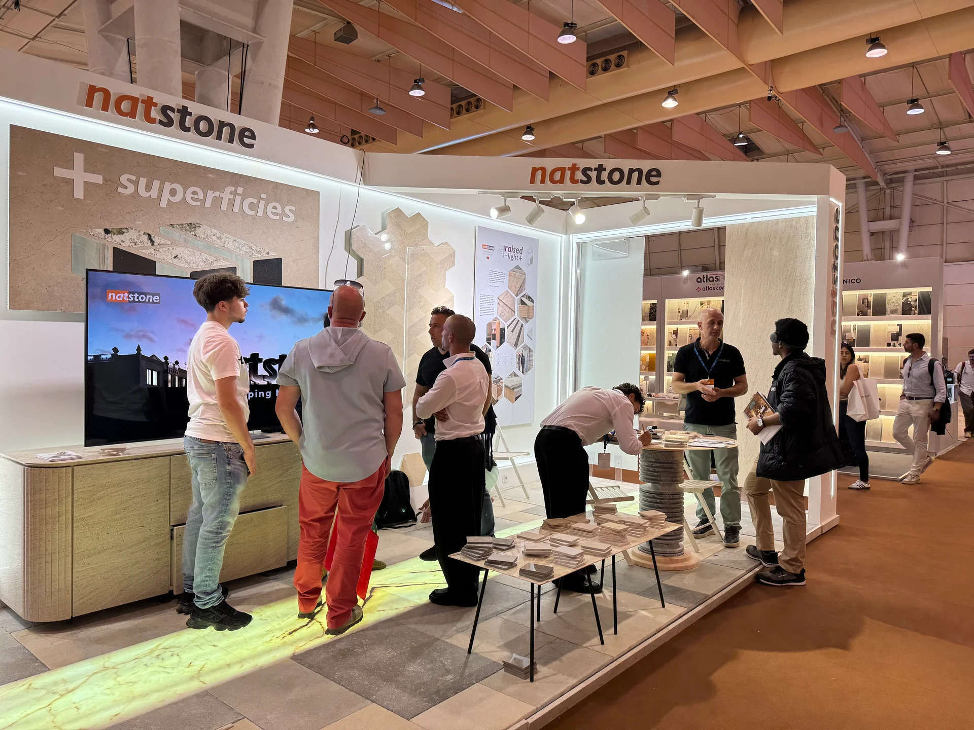 Vue du stand Natstone, des présentoirs et des visiteurs.