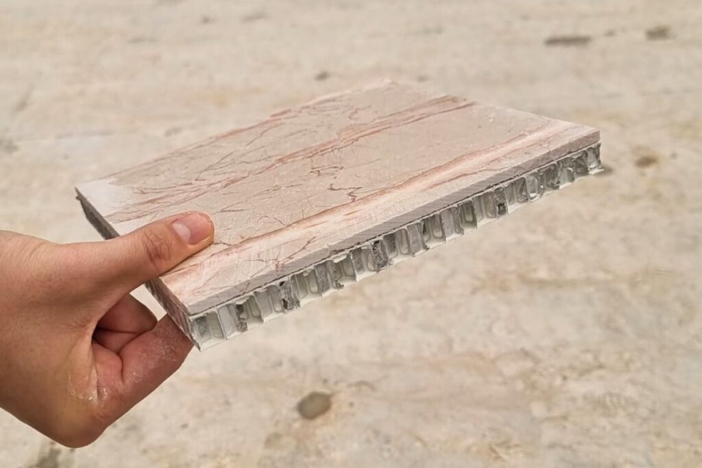 Imagem de um painel leve com acabamento em pedra natural, sustentado por uma estrutura interna tipo favo de mel (honeycomb).